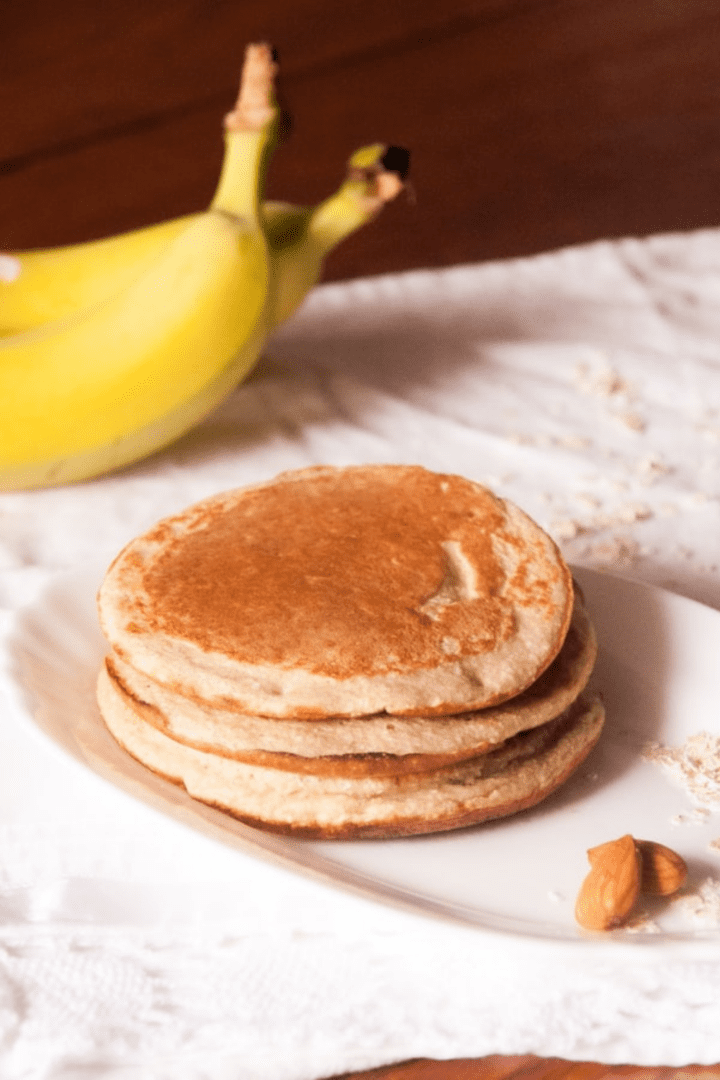 Foto de prato com algumas panquecas, e duas bananas ao fundo.