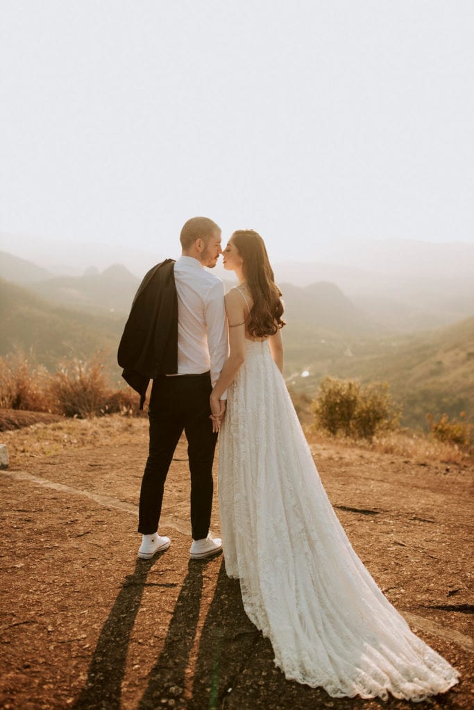 noivos posam no alto de um monte - fotos pós wedding