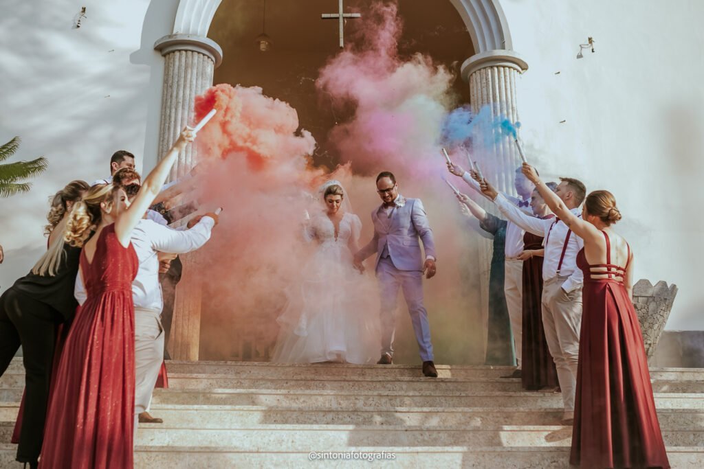 noivos saindo da igreja e sendo festejados pelos padrinhos